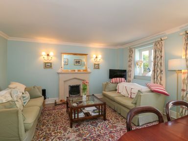 A living room with two sofas a coffee table a fireplace and a window at Batemans Nailsworth