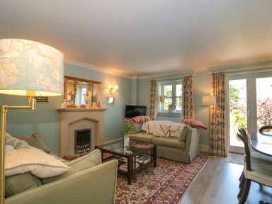 A living room with sofas a fireplace a coffee table and a dining table at Batemans in Nailsworth