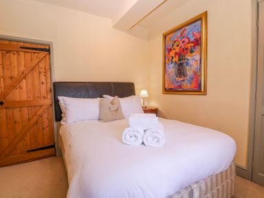A bedroom with a bed and painting at Elm View in Chipping Campden