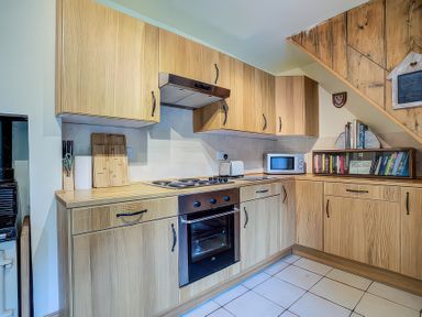 A kitchen with wooden cabinets and appliances at Elm View Chipping Campden