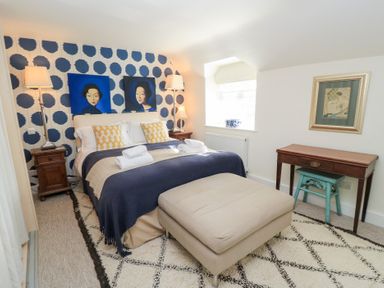 A bedroom with a bed and artwork at Fairview Cottage in Milton-Under-Wychwood