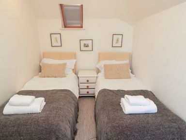 A bedroom with two beds and wall art at Fairview Cottage in Milton-Under-Wychwood