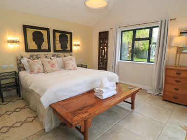 A bedroom with a bed and artwork at Fairview Cottage in Milton-Under-Wychwood