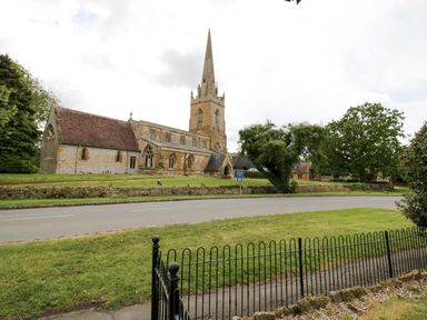 A church building with a steeple near a road at Elmhurst Cottage in Lower Quinton