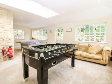 A game room with a foosball table ping pong table and a sofa at South Hill Farmhouse in Stow-On-The-Wold