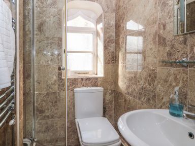 A small bathroom with a toilet sink shower and frosted window at South Hill Farmhouse in Stow-On-The-Wold