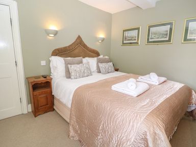 A bedroom with a double bed and two bedside cabinets at South Hill Farmhouse in Stow-On-The-Wold
