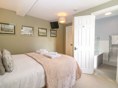 A bedroom with a bed covered with towels and pictures on the wall at South Hill Farmhouse in Stow-On-The-Wold