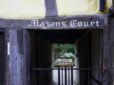 A wooden entrance with the sign Masons Court and a gate with a private sign at One Masons Court in Stratford upon Avon