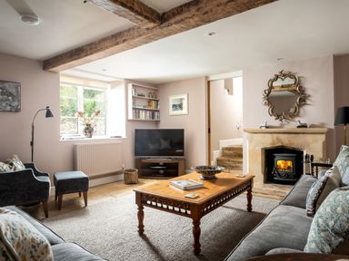 A living room with a wooden coffee table two sofas a fireplace and a television at Orchard House in Stow-On-The-Wold