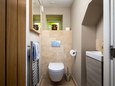 A small bathroom with a wall-mounted toilet a towel rack and a small sink at Orchard House in Stow-On-The-Wold