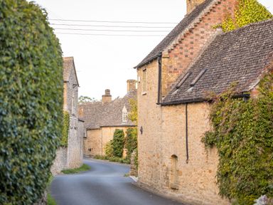 A narrow road between stone houses with ivy on walls at Orchard House in Stow-On-The-Wold