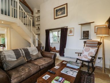 A living room with a sofa and coffee table at The Old Reading Room in Bledington near Stow-on-the-Wold