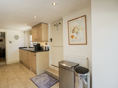 A kitchen with cabinets and a sink at The Old Reading Room in Bledington near Stow-on-the-Wold