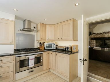 A kitchen with cabinets and appliances at The Old Reading Room in Bledington near Stow-on-the-Wold