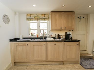 A kitchen with cabinets and appliances at The Old Reading Room Bledington near Stow-on-the-Wold