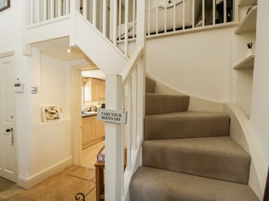 A staircase leading to a kitchen area at The Old Reading Room in Bledington near Stow-on-the-Wold