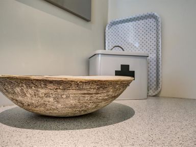 A textured bowl and a white container with a black cross on a countertop at The Old Dairy in Shilton
