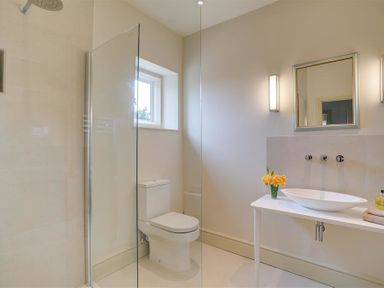 A bathroom with a walk-in shower toilet sink and mirror at The Old Dairy in Shilton