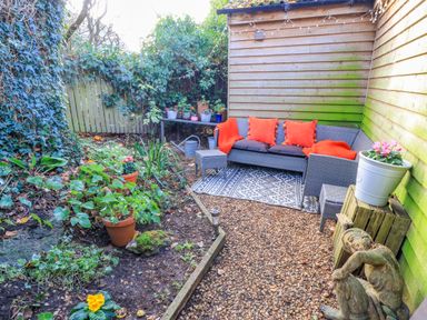 A garden with seating area and potted plants at The Linhay in Little Coxwell near Faringdon