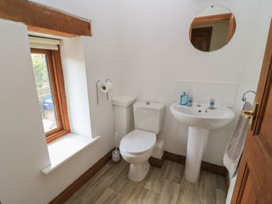 A bathroom with a toilet and sink at Tithe Barn, Lyneham