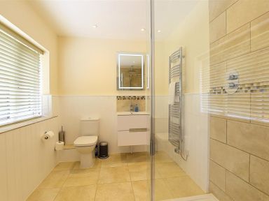 A bathroom with a toilet sink and glass shower at Court Hayes Farm Barns Bourton-On-The-Water