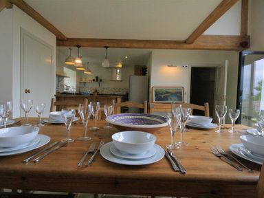 A dining table set with plates bowls cutlery and glasses in a kitchen and dining area at Stepwell in Moreton-In-Marsh