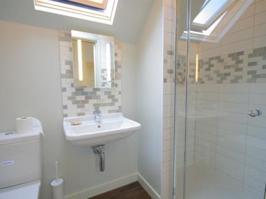 A bathroom with a toilet a sink a mirror and a glass shower enclosure at Stepwell in Moreton-In-Marsh