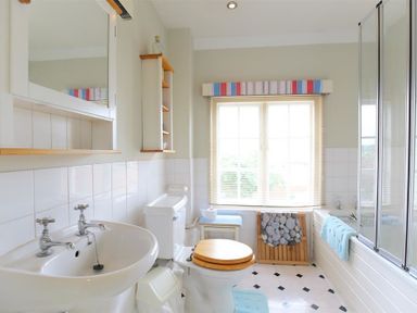 A bathroom with a sink toilet bathtub and window with blinds at The Mews Cottage in Tisbury