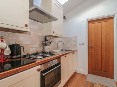 A kitchen with a gas stove oven sink wooden door and various utensils at Russet in Martin