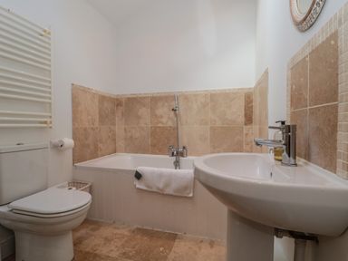 A bathroom with a toilet towel warmer bathtub and sink at Russet in Martin