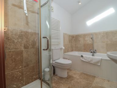 A bathroom with a glass shower enclosure toilet bathtub with a towel and sink at Russet in Martin