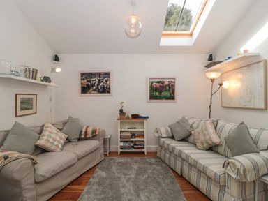 A small living room with two sofas and a bookshelf under a skylight at Pippin in Martin