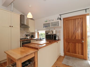 A kitchen with wooden countertops a wooden door a small wooden table and various kitchen appliances at Pippin in Martin