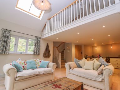 A living room with two sofas and a wooden coffee table under a skylight at Bridge Studio in Broad Chalke
