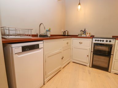 A kitchen with dishwasher sink kettle and oven at Bridge Studio in Broad Chalke