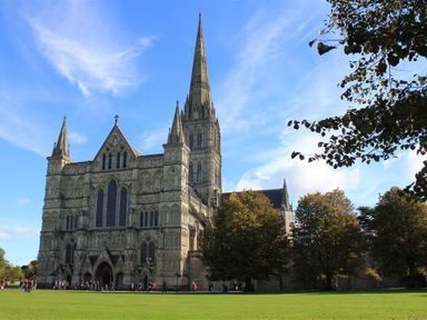 A large cathedral with a tall spire and trees surrounding it at Pop's Barn in Downton