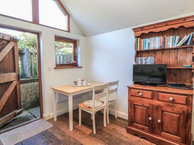 A dining room with a table and chairs at Pop's Barn in Downton