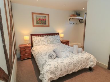 A bedroom with a bed and nightstands at Pop's Barn in Downton