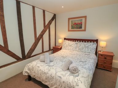 A bedroom with a bed and bedside tables at Pop's Barn in Downton