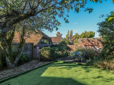 A garden with a table and chairs surrounded by greenery at Pop's Barn in Downton