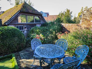 A garden with a table and chairs near a shed at Pop's Barn in Downton