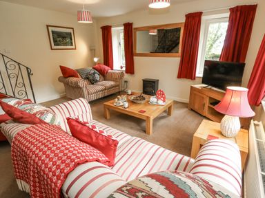 A living room with a sofa and television at Droop Farm Cottage in Droop near Hazelbury Bryan