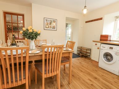 A dining room with a table set for a meal at Droop Farm Cottage Droop near Hazelbury Bryan