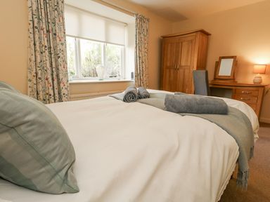 A bedroom with a bed and dresser at Droop Farm Cottage in Droop near Hazelbury Bryan