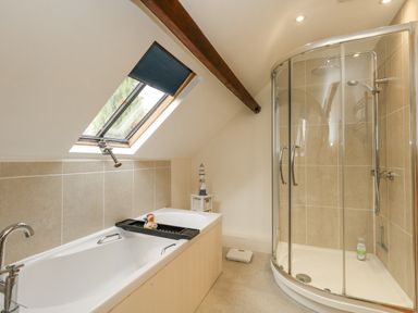 A bathroom with a bathtub and shower at Droop Farm Cottage in Droop near Hazelbury Bryan