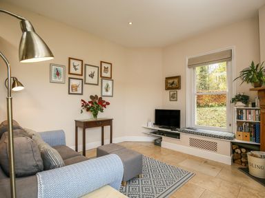 A sitting room with a sofa a wooden table and framed pictures on the wall at West Lodge in Rockbourne