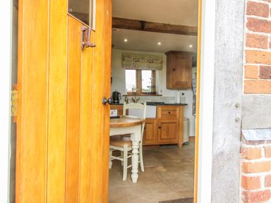 A kitchen with a table and chairs visible from the doorway at The Shooting Folly in Cheswardine