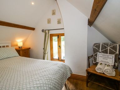 A bedroom with a bed and a window at The Shooting Folly in Cheswardine