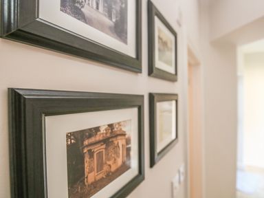 A hallway with four framed pictures on the wall at East Lodge in Rockbourne